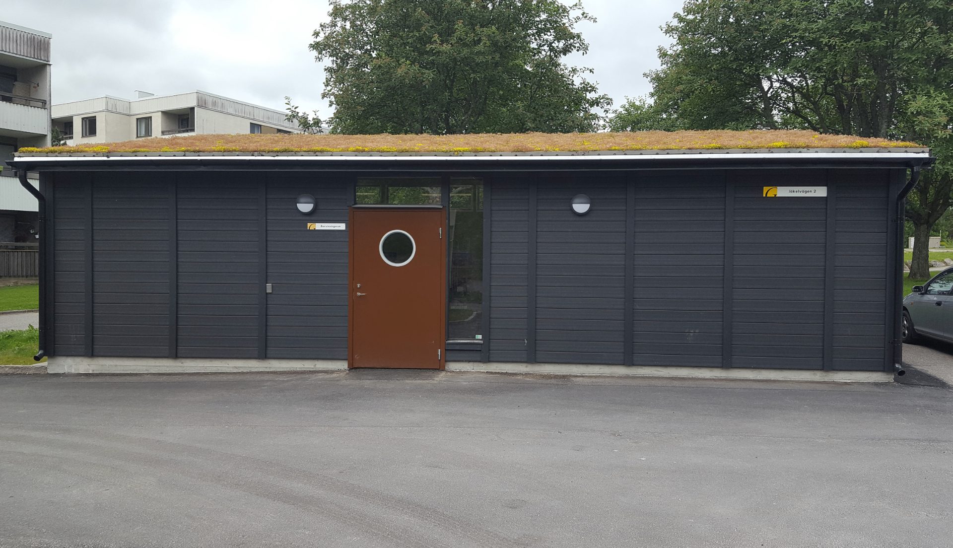 Miljöhus med mörka fasader och sedumtak på en bostadsgård